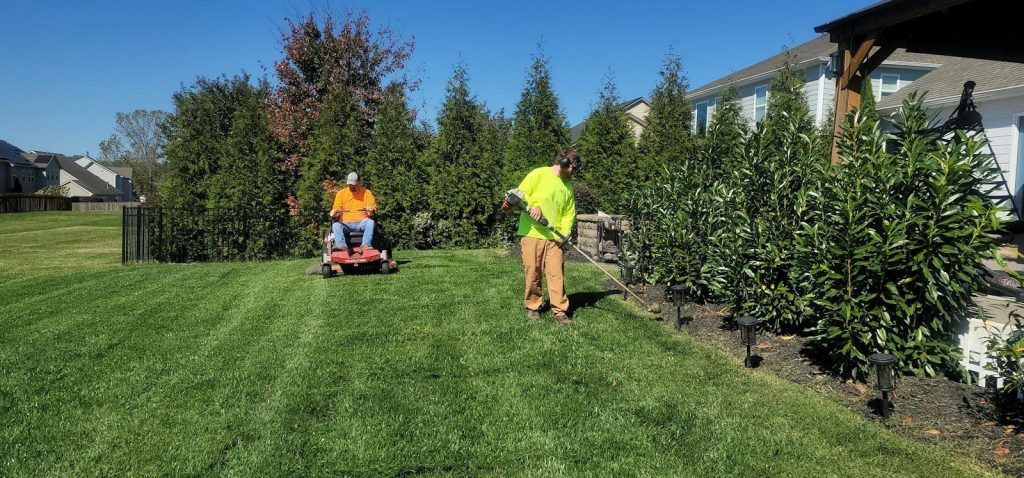 Lawn care worker mowing a large grass area